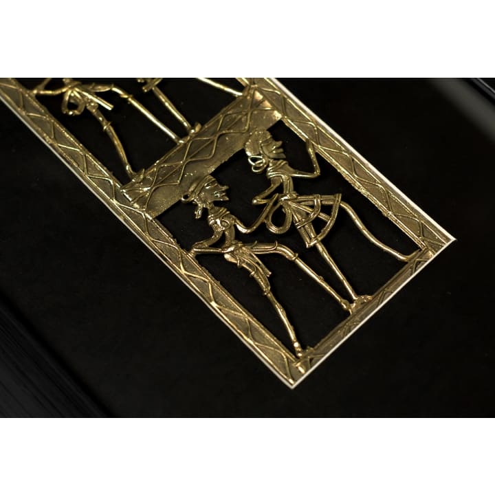 Top-down view of handmade brass dance artwork, emphasizing rich brass detailing and deep black mounting.