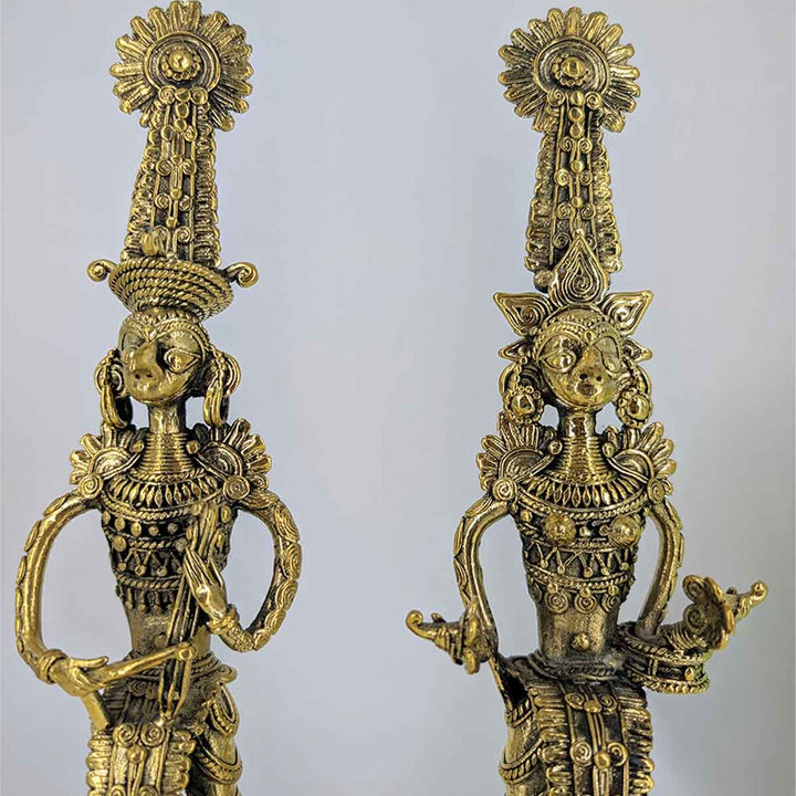 Close-up of intricate tribal engravings on brass Jhitku Mitki figurines.