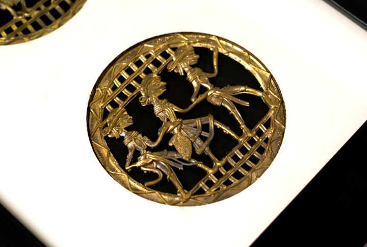 Close-up of intricate Dhokra brass craftsmanship depicting tribal dancers in motion.
