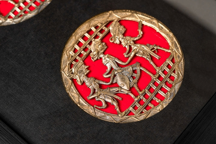 Close-up of intricate Dhokra brass craftsmanship depicting synchronized folk dancers against a bold black backdrop.